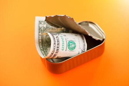 dollars in sardines can on color backgroundの写真素材