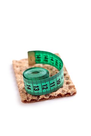 crispbread with measuring tape on white backgroundの写真素材
