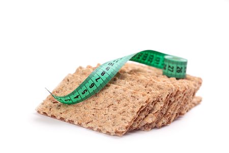 crispbread with measuring tape on white backgroundの写真素材