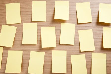yellow note paper on wooden backgroundの写真素材