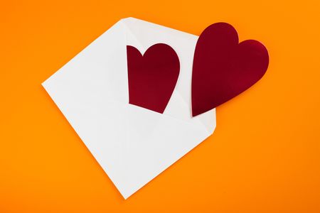 red heart in paper envelope on orange backgroundの写真素材