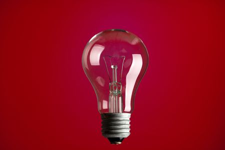 photo shot of light bulb on red backgroundの写真素材