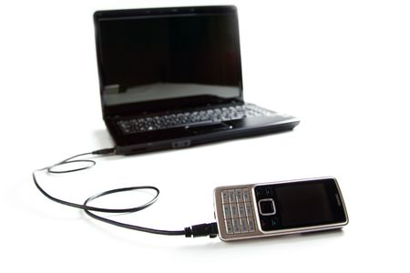 connected cellphone to laptop on white backgroundの写真素材
