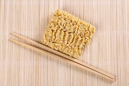 dried chinese noodles and chopsticks on tableの写真素材