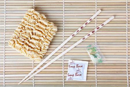 dried chinese noodles and chopsticks on tableの写真素材
