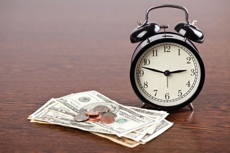 the alarm clock and money on wooden backgroundの写真素材