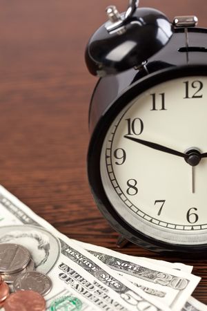 the alarm clock and money on wooden backgroundの写真素材