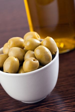 olives and olive oil on wooden tableの写真素材