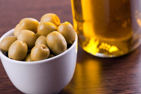 olives and olive oil on wooden tableの写真素材