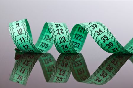 the green measuring tape on wooden backgroundの写真素材