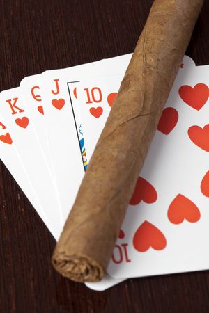 cigar and playing cards on wooden table