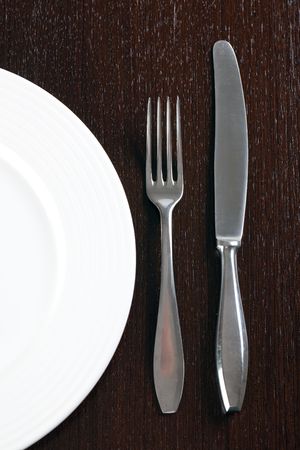 plate and cutlery on wooden tableの写真素材