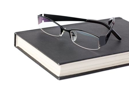 glasses and book on white tableの写真素材
