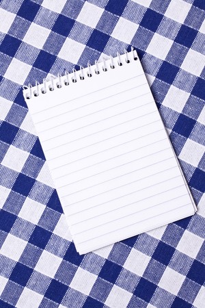 spiral notepad on picnic tableclothの写真素材