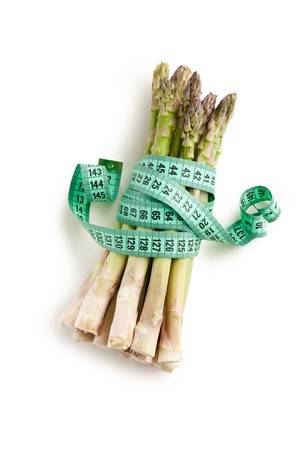 the detail of fresh green asparagus with measuring tapeの写真素材