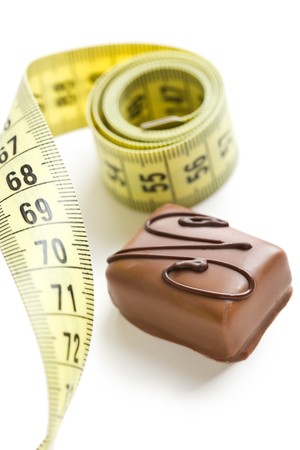 chocolate praline with measuring tape on white backgroundの写真素材