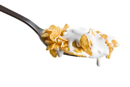 the cornflakes on the spoon with milk の写真素材