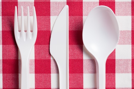 the plastic cutlery on checkered tableclothの写真素材