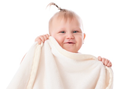 adorable baby playing with white blanket in studioの写真素材