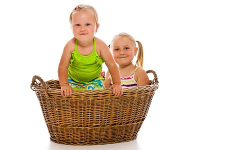 siblings in big basket on white backgroundの写真素材