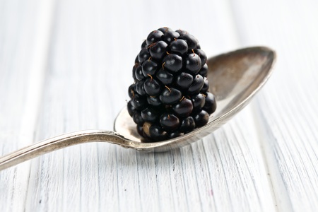 blackberry fruit in silver spoon on wooden table