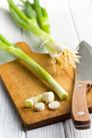 cutting spring onions on kitchen tableの写真素材