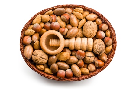 wooden nutcracker and nuts in basket on white backgroundの写真素材