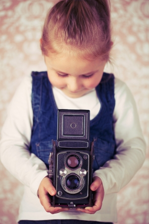young girl in studio with analogue camera の写真素材