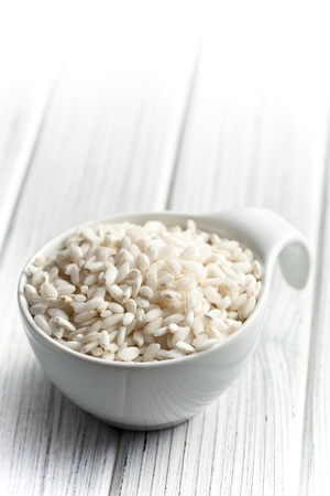 the uncooked arborio rice in bowlの写真素材