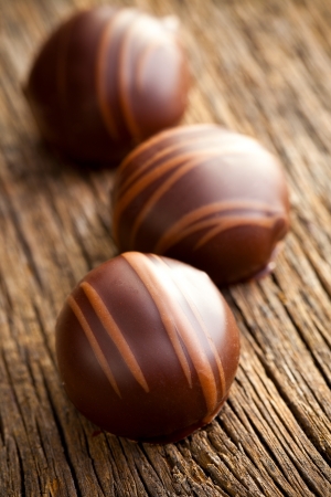 chocolate pralines on old wooden tableの写真素材
