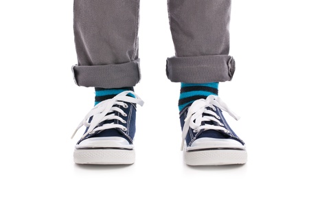 Close-up on child feet with sneakers. Studio shot.