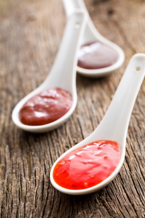 the various barbecue sauces in ceramic spoonsの写真素材