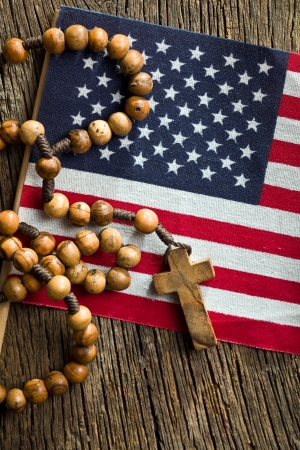 top view of rosary beads with american flag on wooden backgroundの写真素材