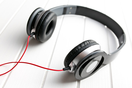 black headphones on white wooden tableの写真素材