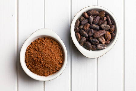 top view of cocoa beans and cocoa powder in bowls