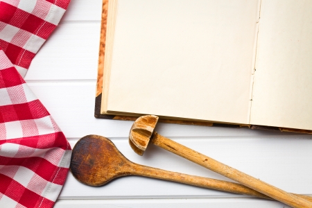 top view of cookbook with kitchenware on white wooden tableの写真素材