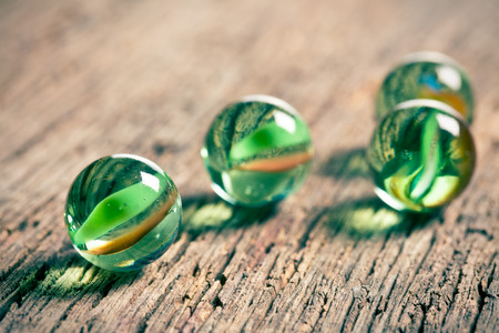 Glass marble balls on old wooden backgroundの写真素材