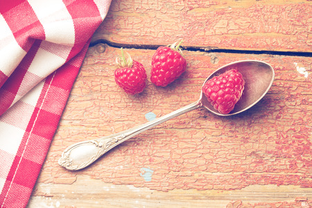 top view of raspberry on silver spoon
