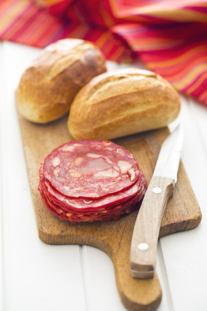 sliced chorizo salami on cutting boardの写真素材