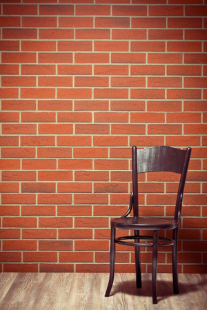 the wooden chair before brick wallの写真素材