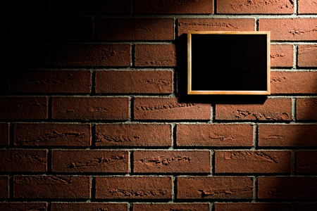 the blank blackboard hanging on brick wallの写真素材