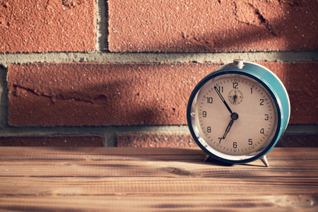 The old clock in front of a brick wallの写真素材