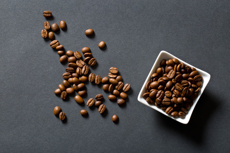 the coffee beans in bowl on black background
