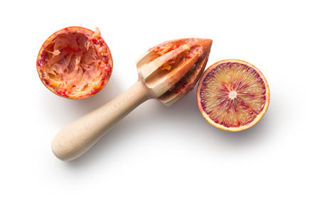 halved blood orange and juicer on white backgroundの写真素材