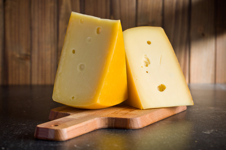 block of edam cheese on kitchen tableの写真素材