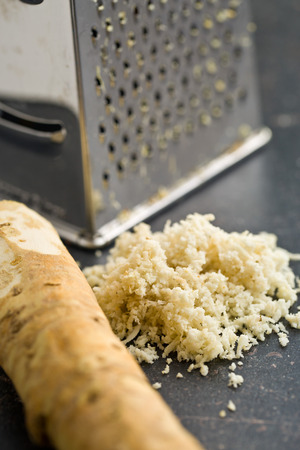 grated horseradish root on kitchen tableの写真素材
