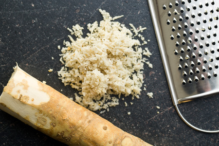 grated horseradish root on kitchen tableの写真素材