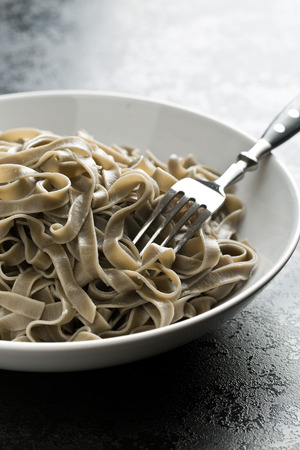 cooked black tagliatelle pasta on plateの写真素材
