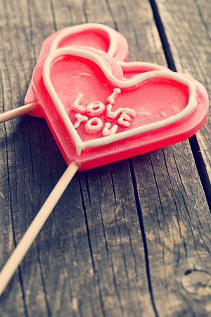 Lollipop heart on a vintage wooden backgroundの写真素材