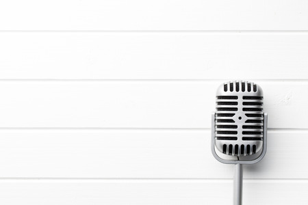 vintage microphone on white wooden background